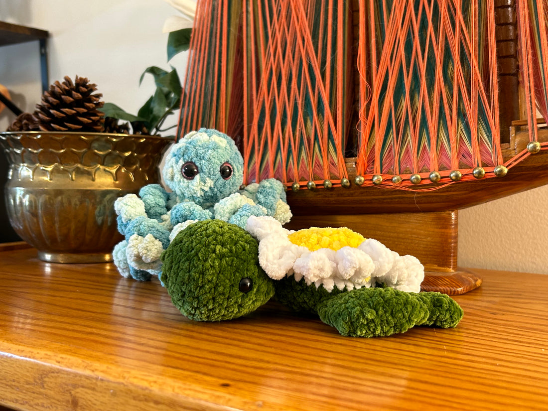 A soft crocheted sea creature and a crocheted daisy sea turtle